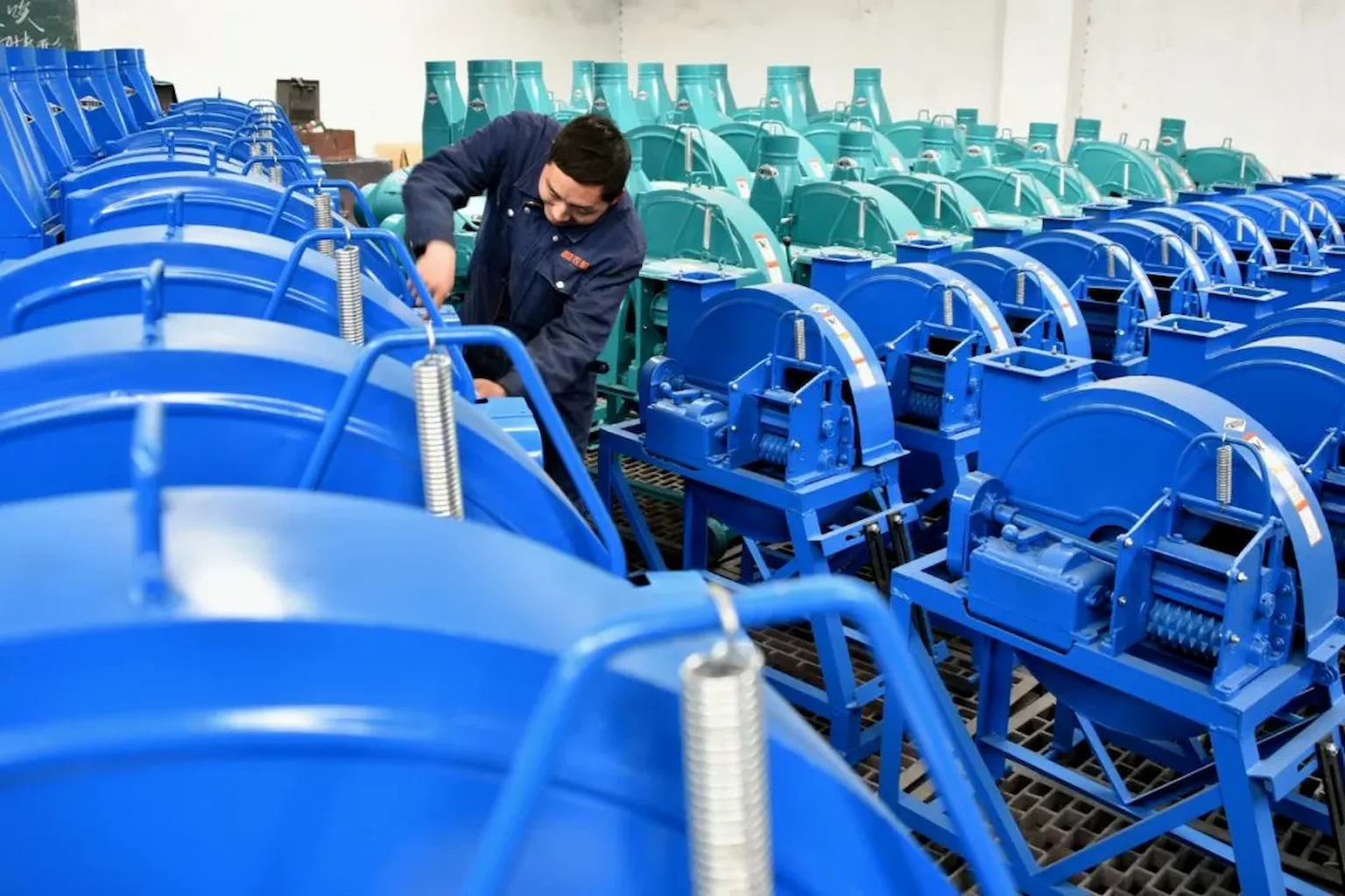 Worker assembling blue chaff cutters