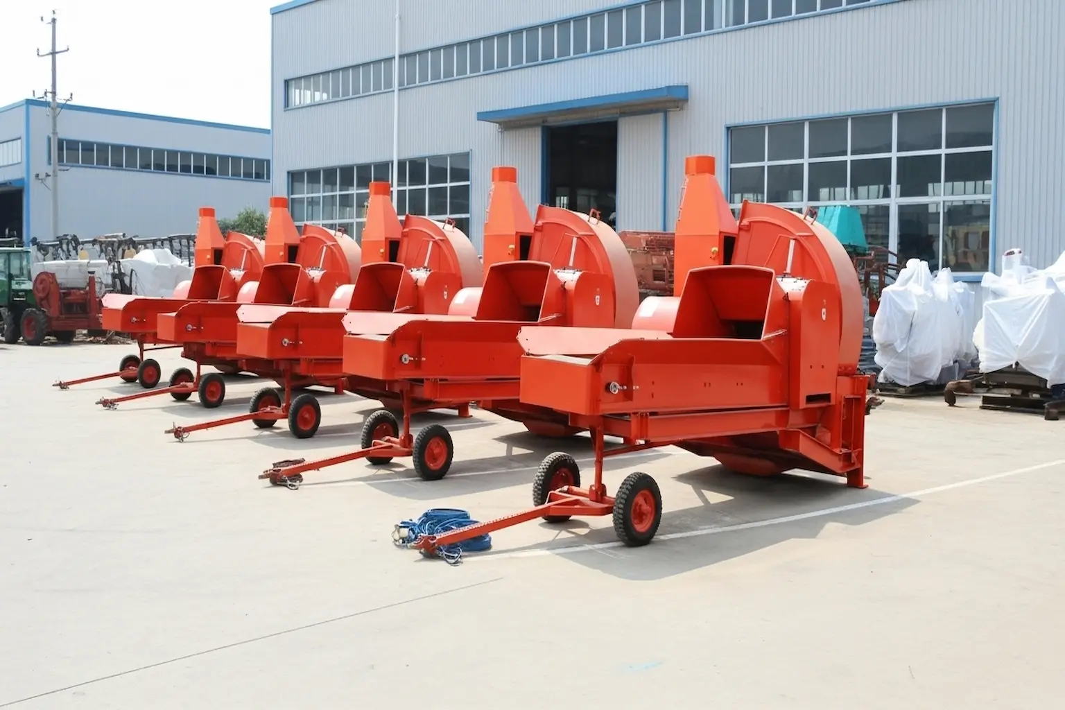 Red chaff cutters lined outside factory
