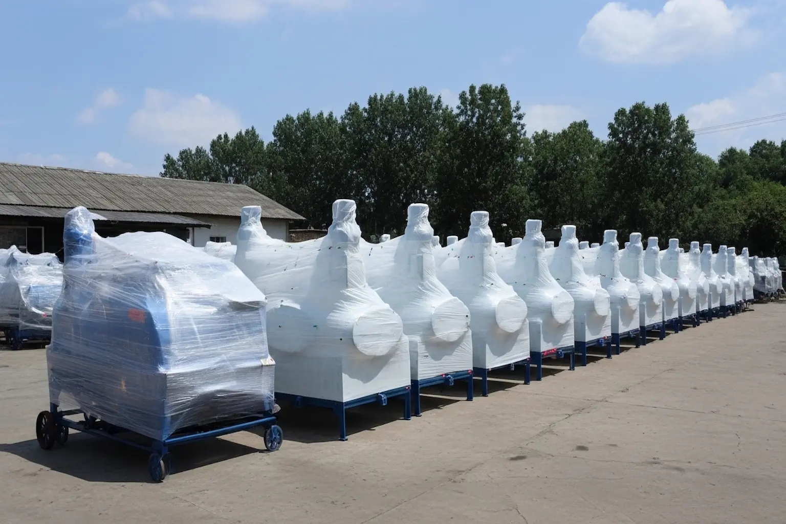 Rows of chaff cutter machines wrapped in protective plastic packaging, prepared for shipment.