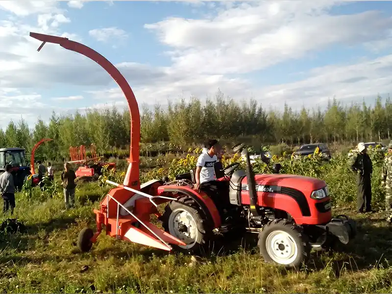 Tractor mounted driven silage chaff cutter machine operating in pastoral ranch