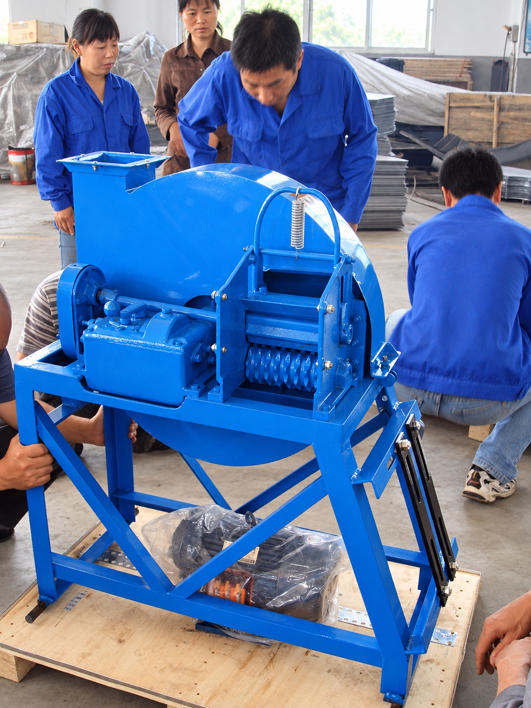 Workshop crew inspecting the supplied blue roller assembly and circular housing