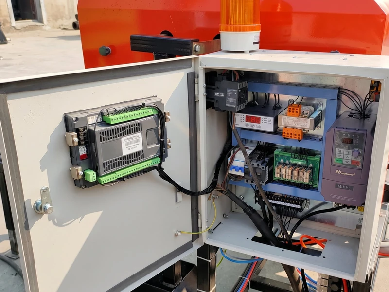 Open control cabinet of the FC-585 silage baler showing the programmable controller, bale counter, relays and frequency inverter