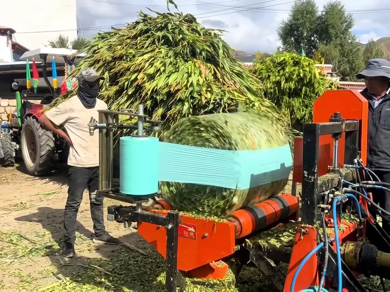 Silage bale wrapped in green film on a PTO-driven FC-585 baler with the tractor drive shaft connected