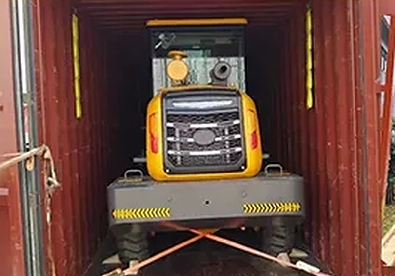 Loader strapped and lashed inside a shipping container